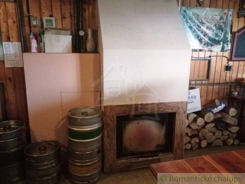 Interior with a fireplace, beer barrels, and wood, ideal for relaxing in a cabin.