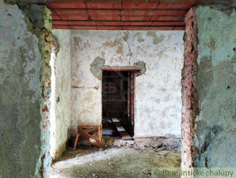 Interior renovation of a family house with exposed brick walls and damaged plaster.