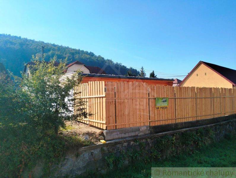 Family house with a garden, wooden fence, nature, forest, hills, property for sale.