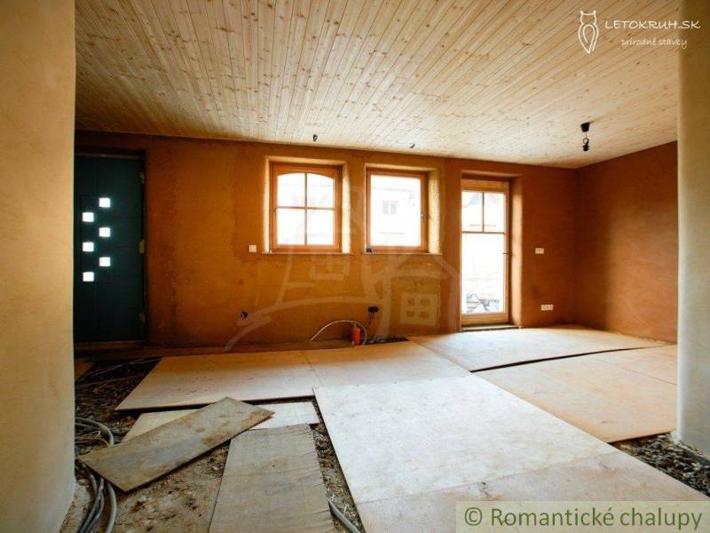 Interior with a wooden ceiling, windows, unfinished floor, and family house.