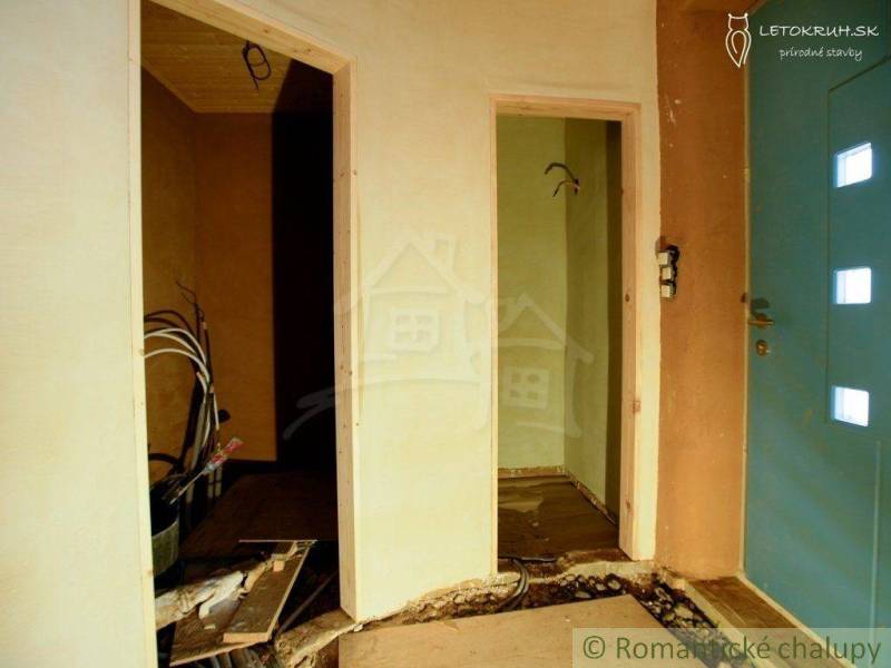 The entrance hall of a family house under renovation, showing wires and wooden paneling.