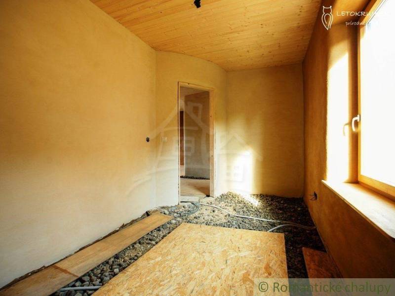 A room in a country house with wooden paneling, preparation for the floor, light through the window.