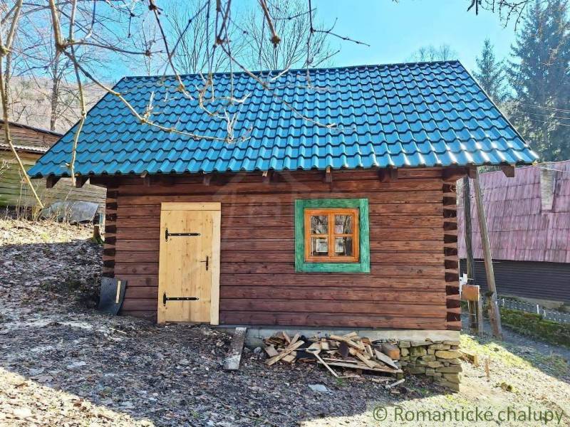 A wooden cabin with a blue roof surrounded by nature, ideal for a weekend getaway.