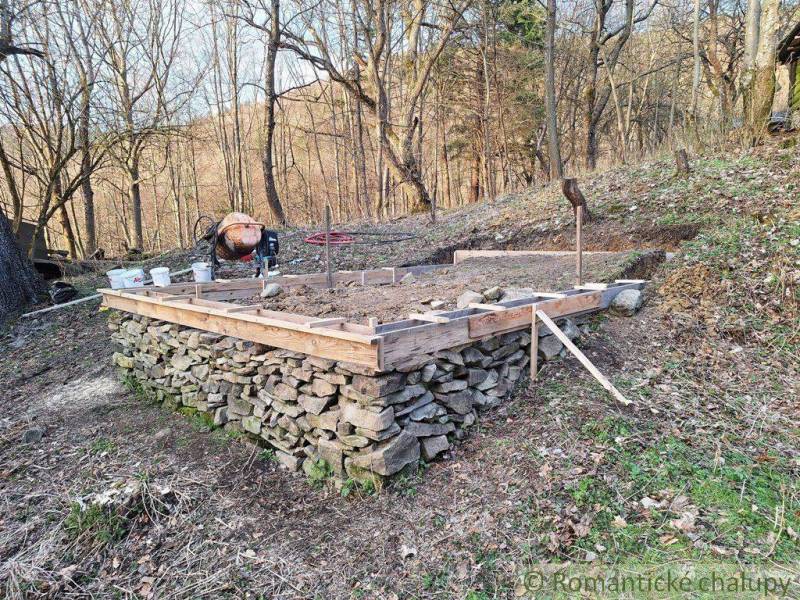 Foundations for a cabin built from rocks in the forest, construction process against the backdrop of nature.