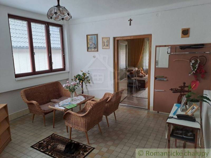 A classic room with rattan furniture, flowers, and windows in a family house offers a cozy atmosphere.