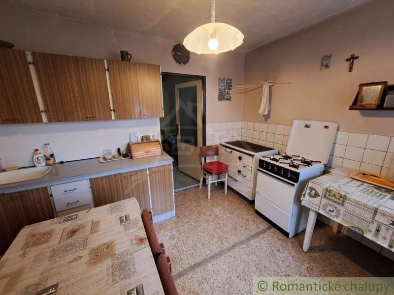 A kitchen with a gas stove and kitchen cabinets in a country house.