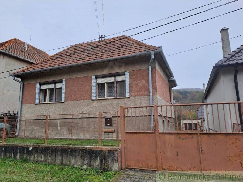 A family house with a gable roof, fence, brick facade, in a quiet location.
