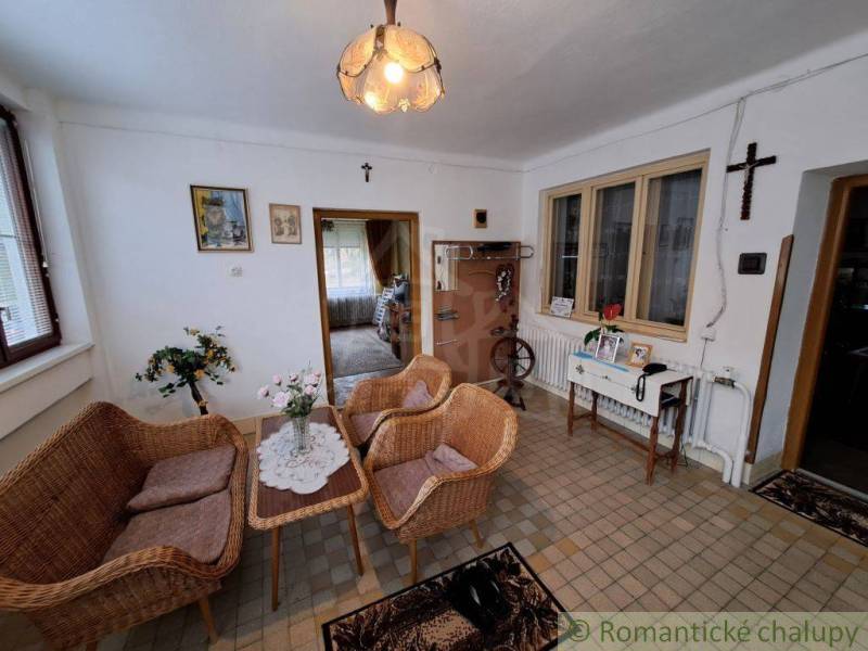 Living room of a family house with wicker furniture, flowers, and traditional decorations.
