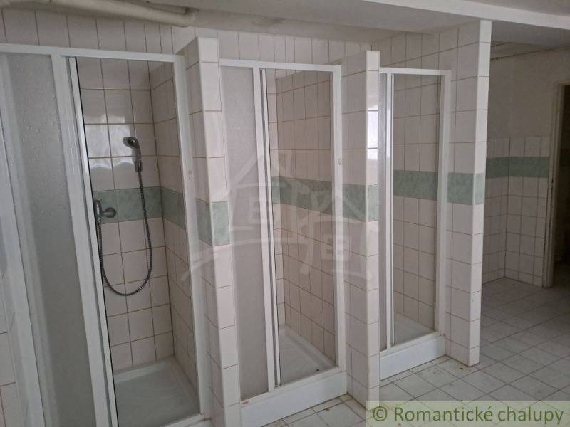 Three shower enclosures with ceramic tiles are part of the public spaces.