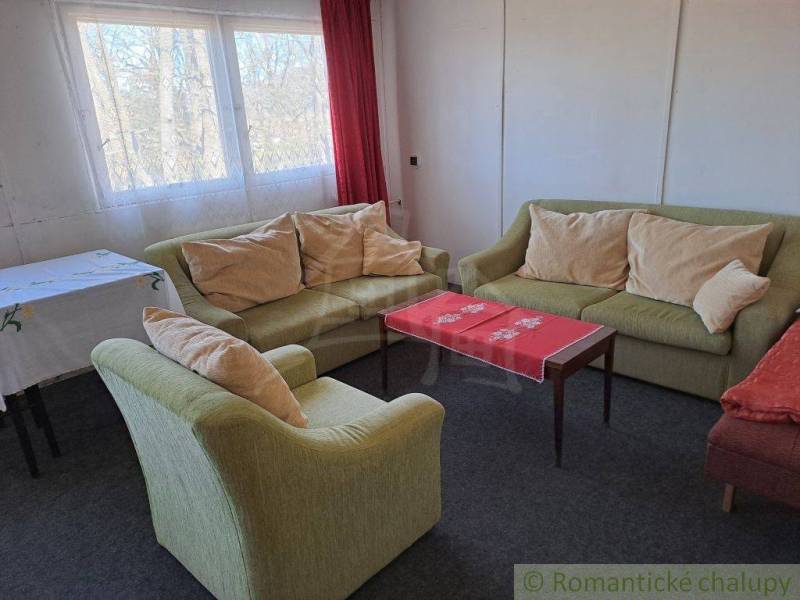 Living room with sofas, a table, and curtains, suitable for commercial spaces.
