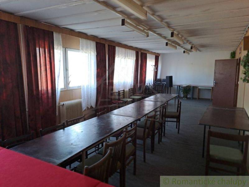 A room with long tables, chairs, and a window; ideal for business spaces.