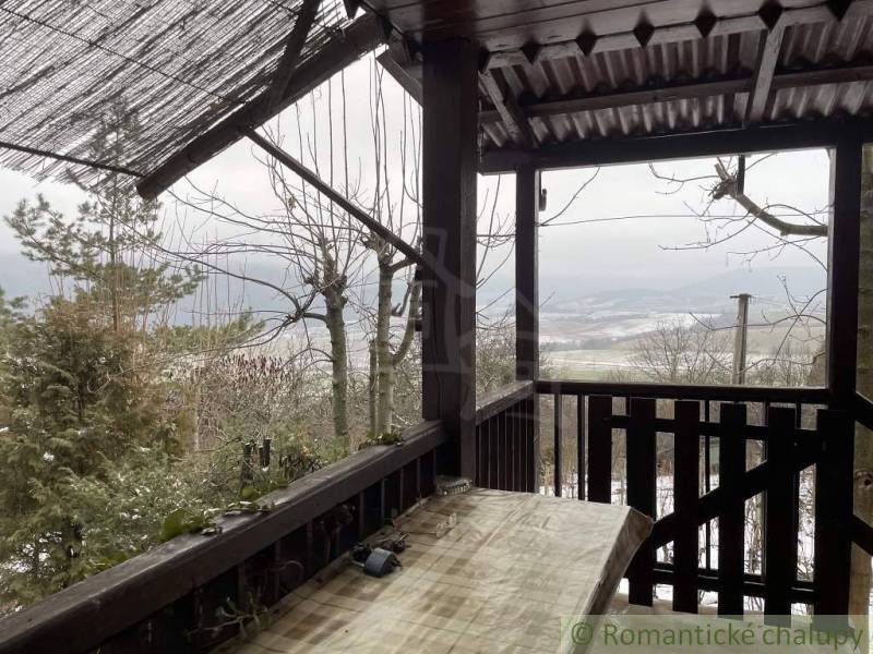 View from the cottage to the snowy landscape, set in a natural environment.