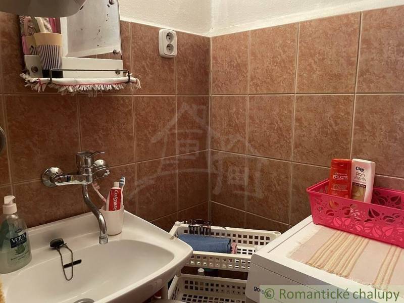 A bathroom in a family house with a mirror, a sink, and storage baskets for toiletries.