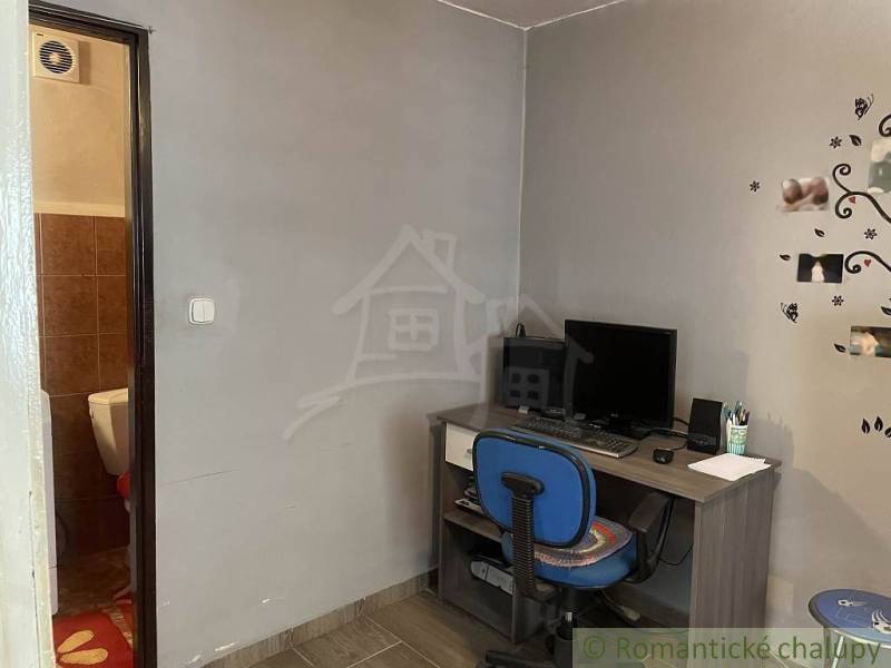 A desk with a computer, chair, bathroom; family house and study corner.