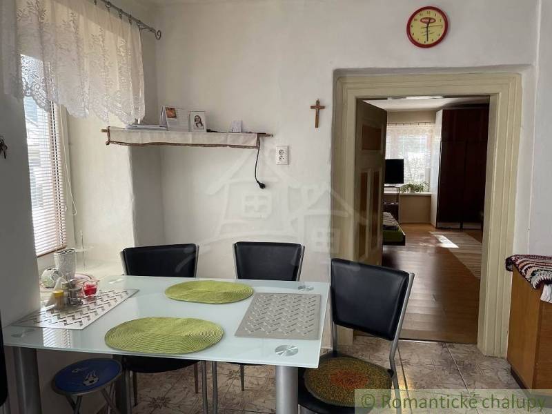 Dining area with a glass table and chairs in a cozy family house.