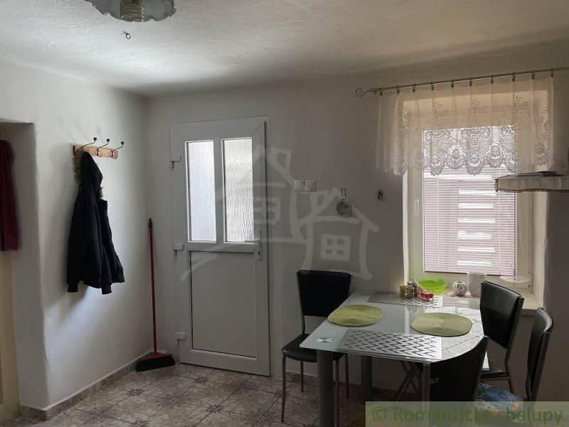 Kitchen, family house, dining table, chairs, entrance door, coat rack, broom, tiles.