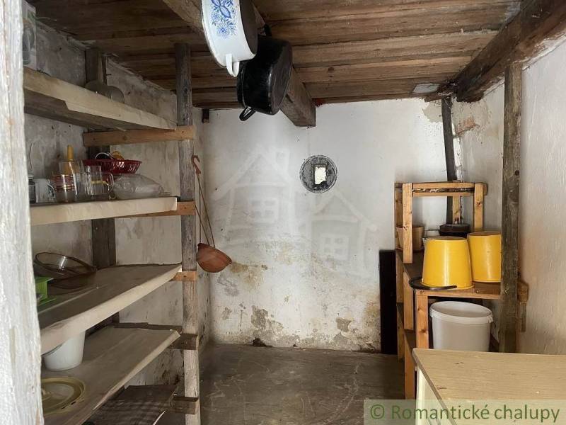 A country pantry full of shelves and kitchen utensils in a family house.