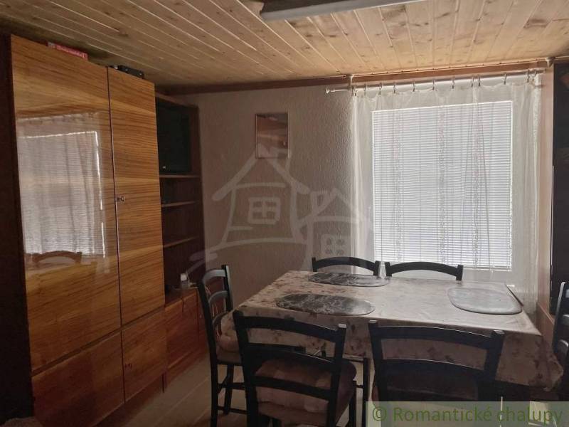 Interior of a cabin, retro furniture, wooden ceiling, dining table with chairs.