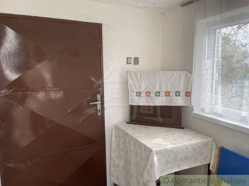 Brown door, table with a tablecloth, set in the cozy environment of an attic cabin.