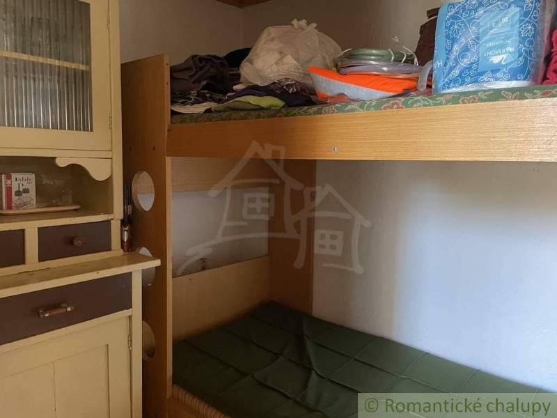 Wooden bunk bed and cabinet in a rustic cottage, traditional elements and cozy atmosphere.