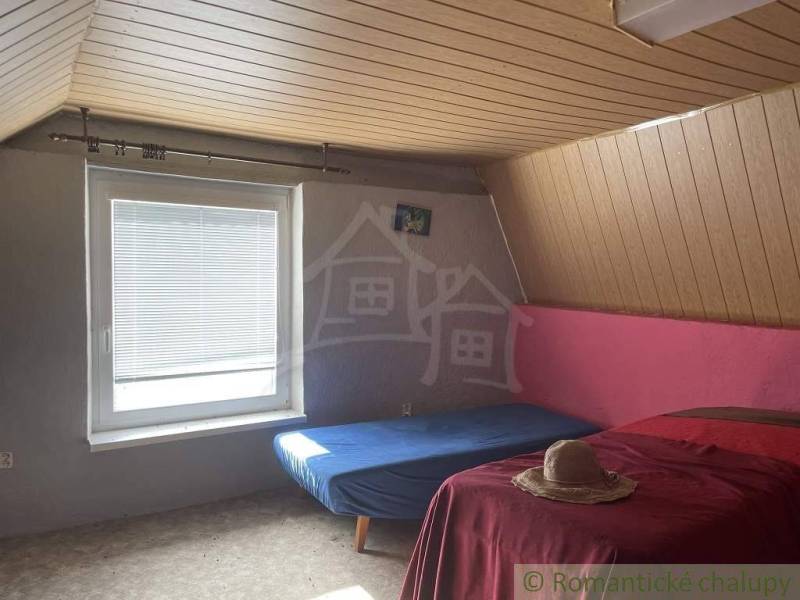 Attic room with a wooden ceiling, comfortable beds in a cottage ideal for a vacation.