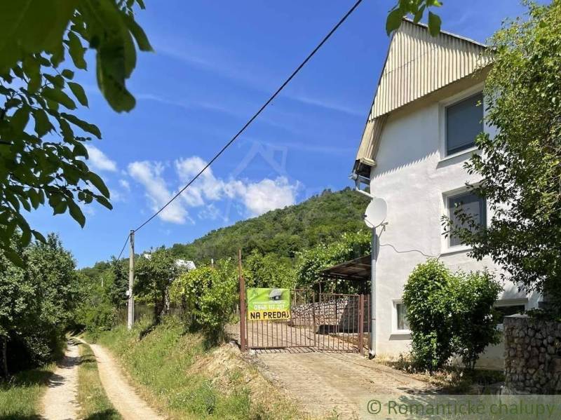 A cottage near Rožňava with a view of the forest road and hilly terrain.