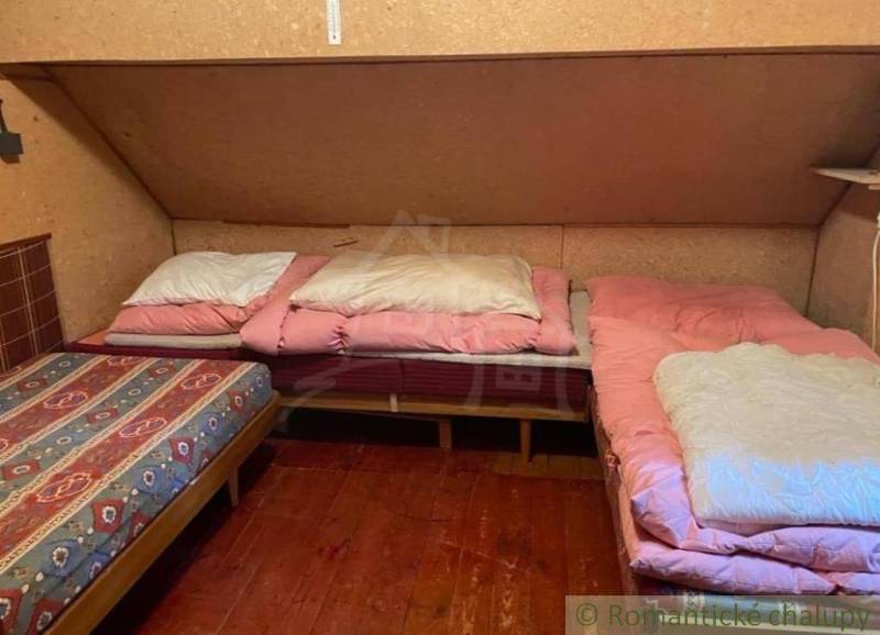 A cottage with antique furniture, simple beds, and wooden flooring, ideal for relaxation.
