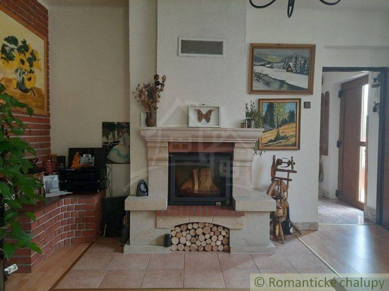 Traditional interior with a fireplace, paintings, and wooden furniture suitable for a family house.