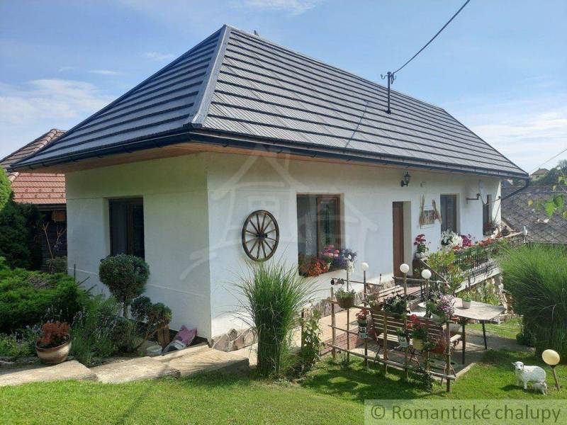 A family house in nature, with a white facade, a garden, and rustic decor.