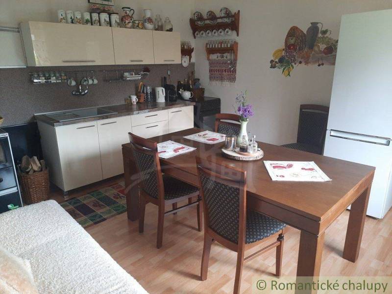 A kitchen in a family house with a wooden table, kitchen unit, and decorations.