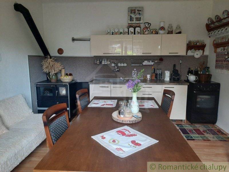 A kitchen in a family house with a wooden table, an antique stove, and decorations.