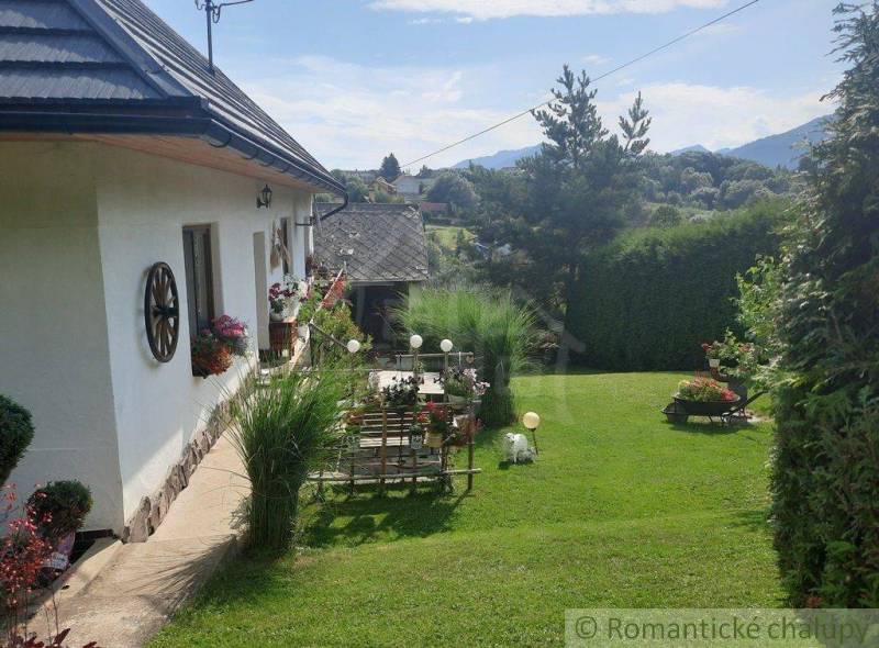 A family house with a garden, flowers, decorations, and dreamy views of the mountain peaks.
