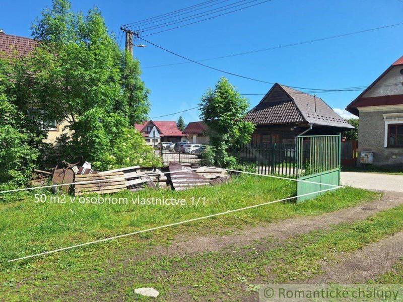 The picture shows a 50 m² plot of land surrounded by family houses and green countryside.