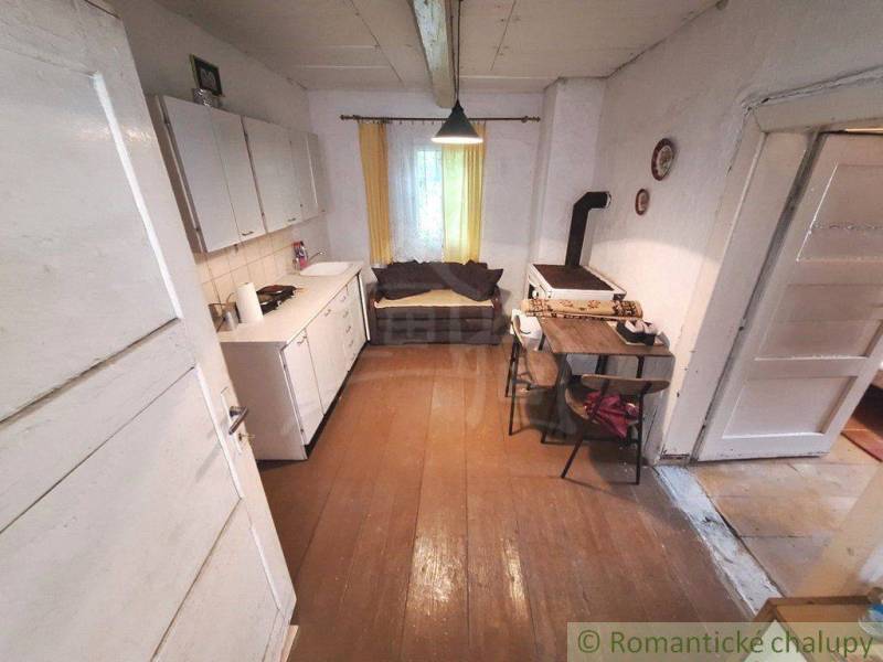 A kitchen with a wooden floor, a stove, and a table in a family house.