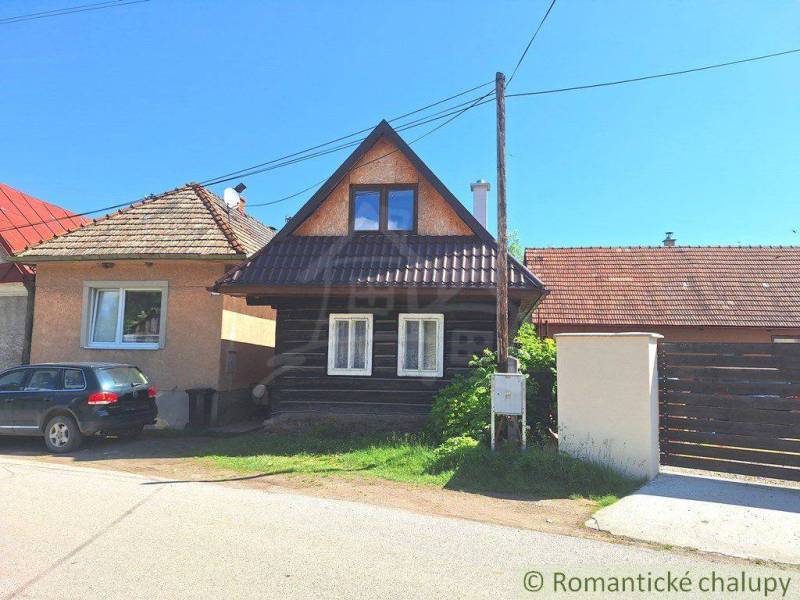 Stone house with a gable roof and a car on the driveway offers family comfort.