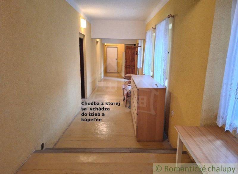 A corridor with wooden furniture, doors leading to rooms, natural light, commercial spaces.
