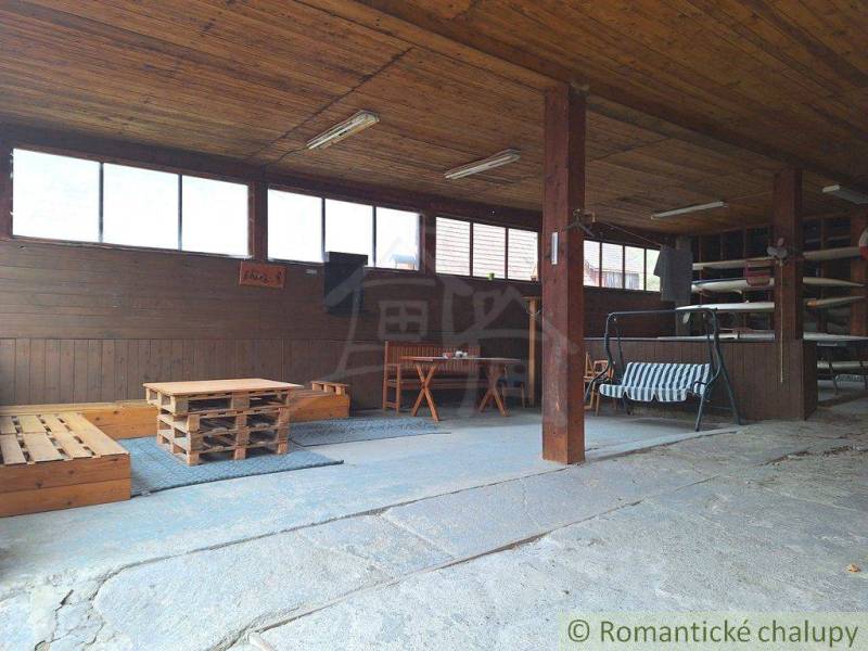 A spacious terrace of a family house with wooden ceilings, seating, and a pleasant atmosphere for relaxation.