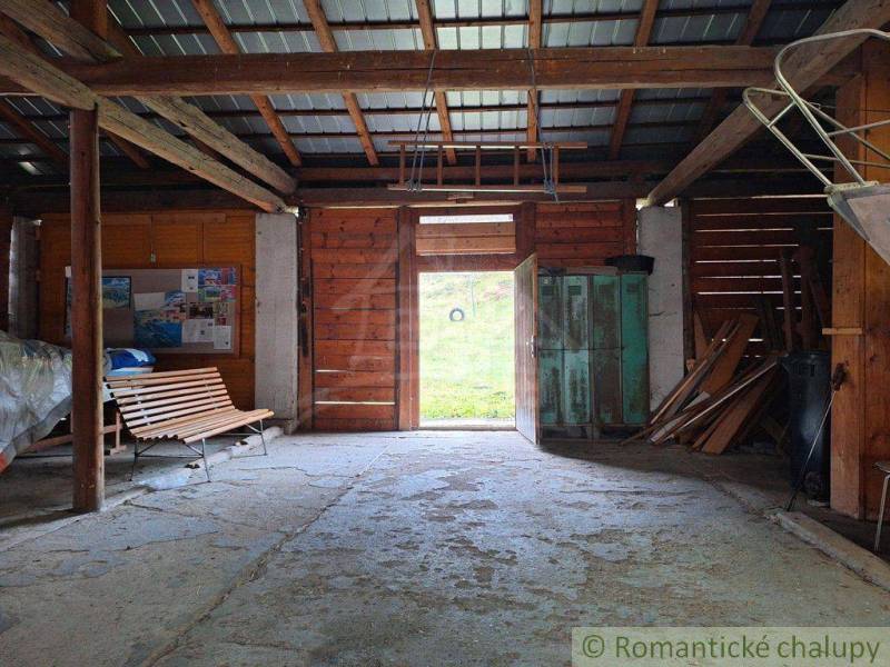 A light wooden garage with a bench and open doors offers rustic charm.
