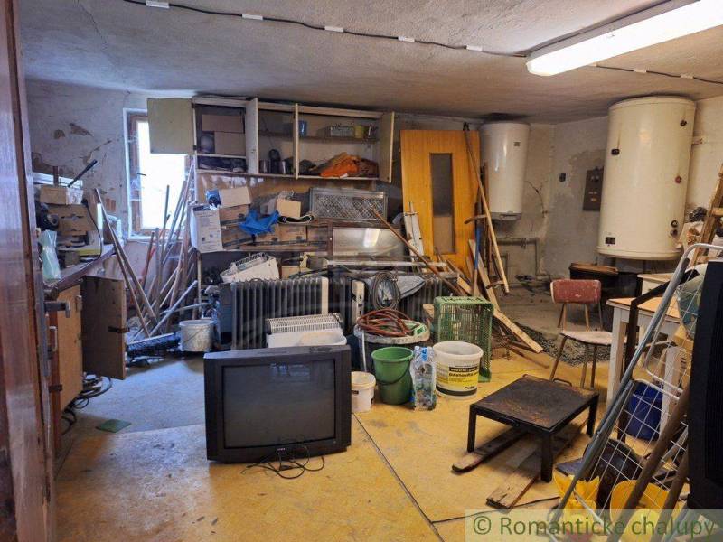An old warehouse with tools, a television, and two boilers offers limited commercial space.