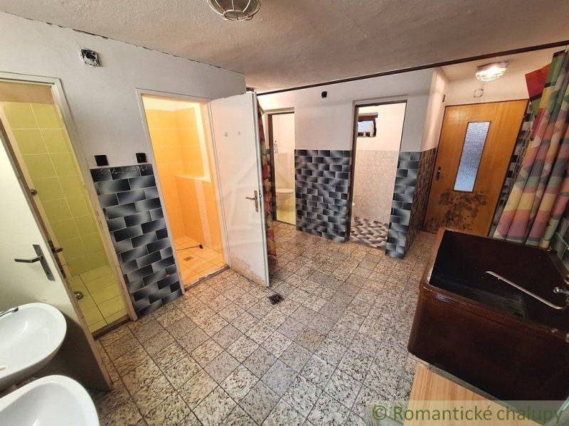 Entrance hall with several doors, tiles, and sinks. Commercial premises.