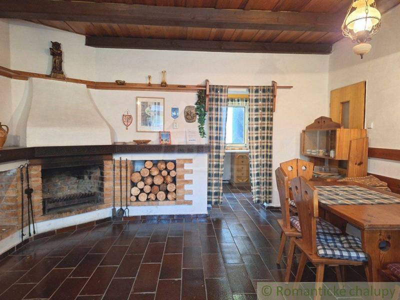 The interior of the cottage features a stylish fireplace, wooden furniture, and decorations. Family house.