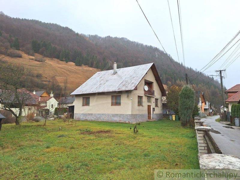 A traditional family house in a picturesque village with a beautiful mountain backdrop.