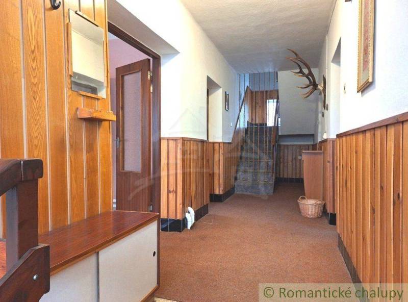 A hallway with wooden paneling and a staircase in a family house with a moving service.