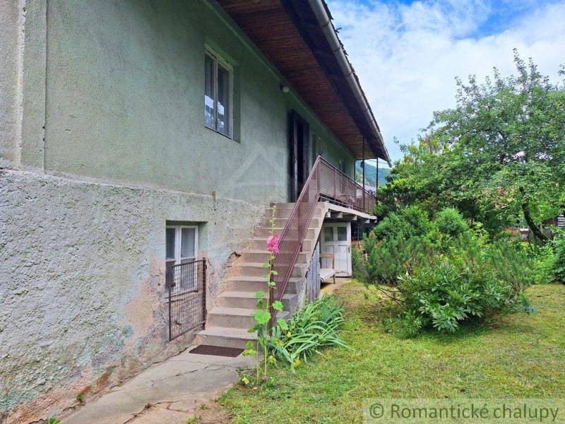 An older house with exterior stairs and a garden, suitable for residential land.