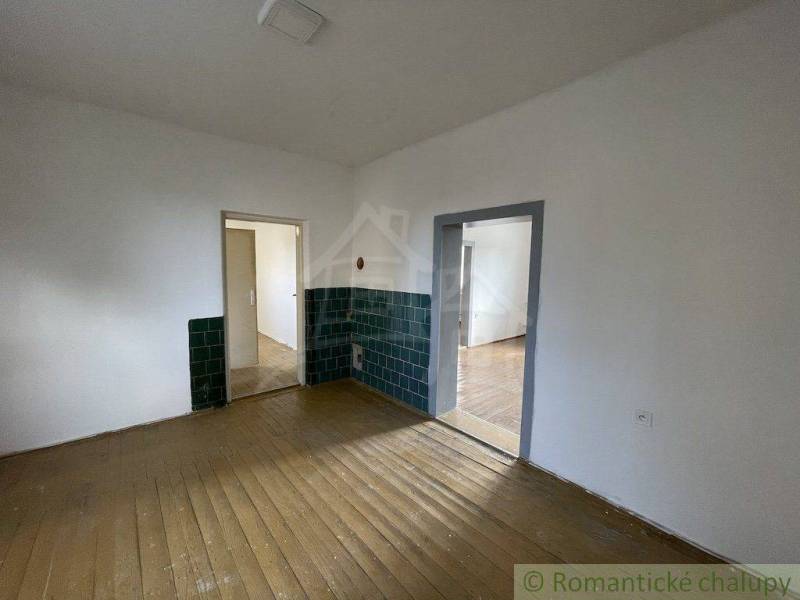 A family house with wooden flooring, white walls, and green tiles.