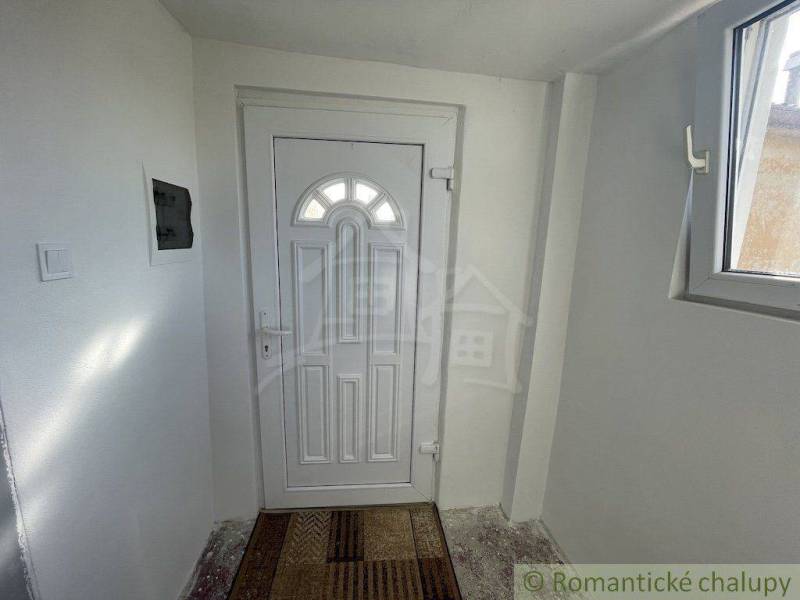 Entrance hallway with white doors, covered with a doormat, in a family house.