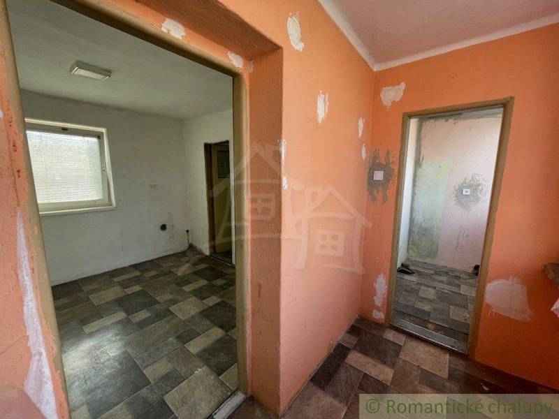 Hallway and rooms of the family house, floors with tiles, walls need renovation.