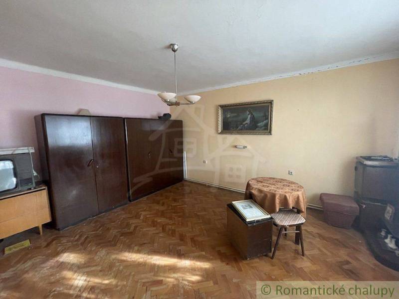A room in a family house with furniture, a painting, and a TV, suitable for living.