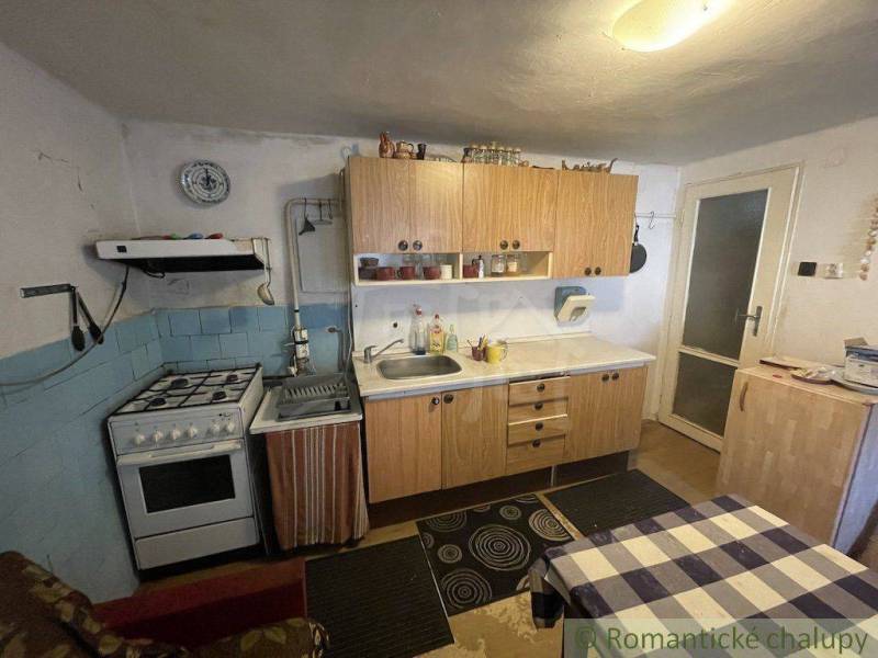 A kitchen in a family house with a gas stove and wooden cabinets.