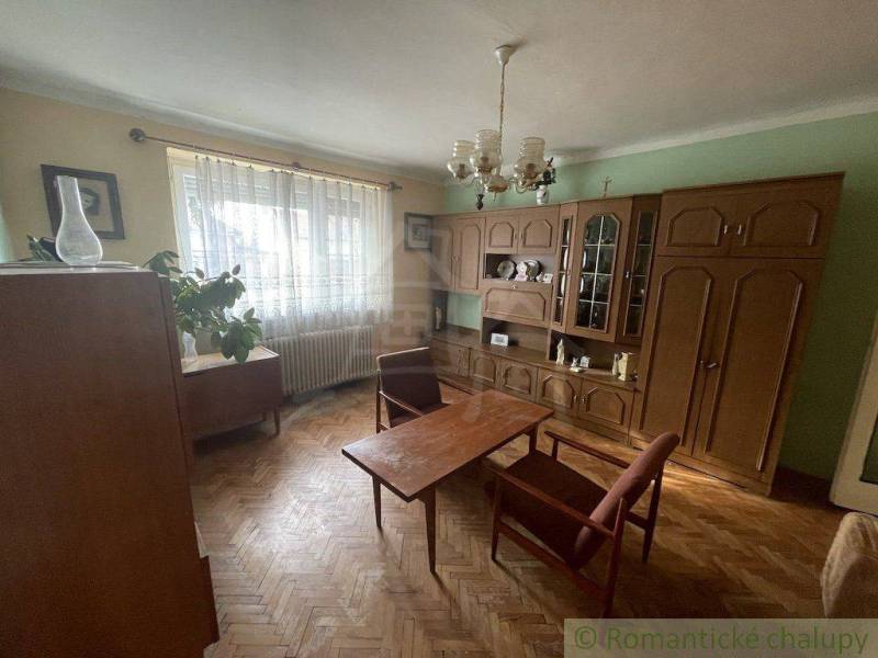 Living room in a family house with antique furniture, parquet flooring, and curtains.
